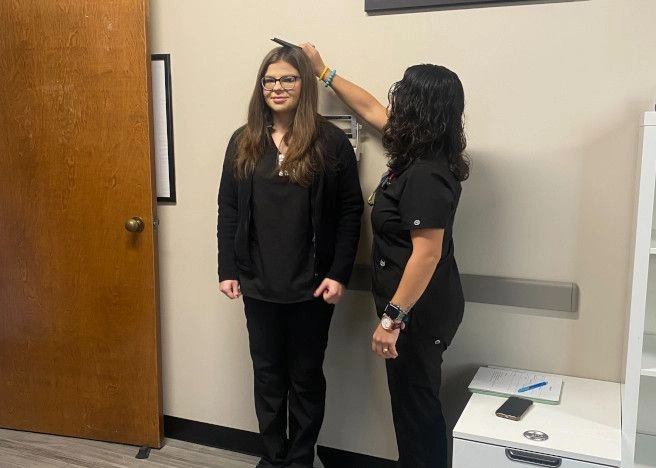 student measuring the height of another student